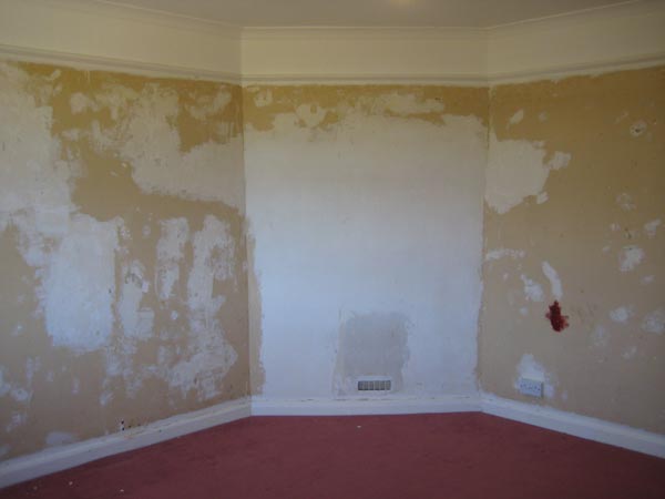 Before — living room walls stripped